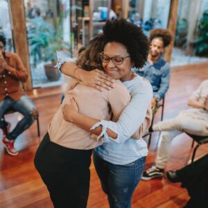 Two women hugging in a support group