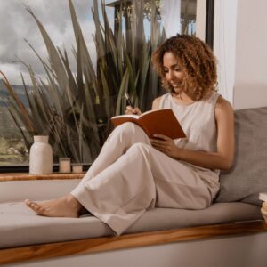 Woman sitting down and writing in her journal