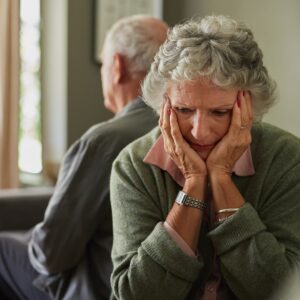 Older couple with backs turned against each other.